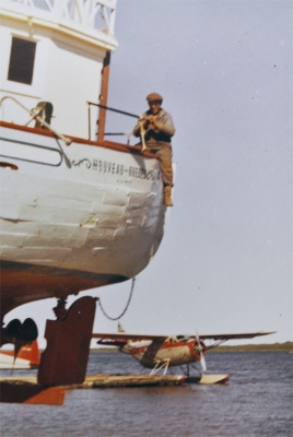 Cree man straddling the side of a schooner